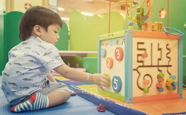 Asyalı çocuk üzerinde eğitici oyuncak oyun. Japon bebek renkli oyuncakla saymak öğrenme. Çocuklar için anaokulu sınıfı Oda pratikte öğrenme numarası.