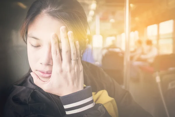 Chica japonesa que tiene un dolor de cabeza en un tren. Las mujeres asiáticas que tienen un mareo en un autobús de viaje . — Foto de Stock