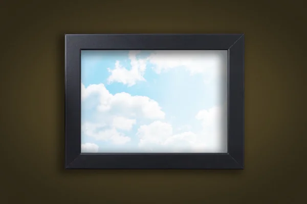 Black photo frame with cloud sky on brown background — Stock Photo, Image