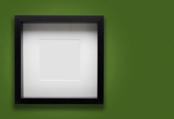 Yeşil duvar üzerinde boş kalın siyah fotoğraf çerçevesi — Stok fotoğraf
