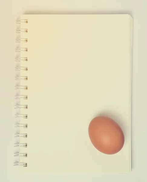 Boş not defteri bağlama sayfa üzerinde yumurta — Stok fotoğraf