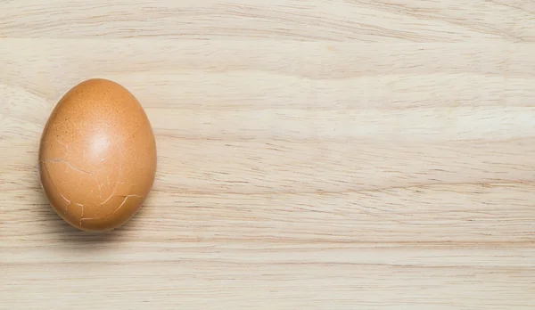 Ράγισμα αυγού σε ξύλινο υπόβαθρο για αντίγραφο χώρου και κείμενο. — Φωτογραφία Αρχείου