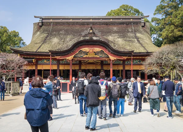A large group of Chinese tourists are walking in to Dazaifu Shrine.
