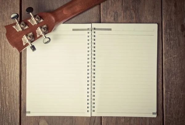 Cabeza de guitarra en un libro para escribir canciones —  Fotos de Stock