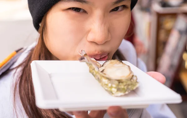 Japanisches Mädchen isst frische Hiroshima-Auster — Stockfoto