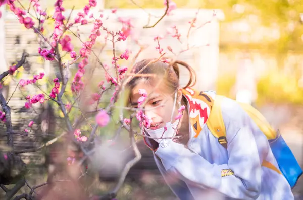 Japonês adolescente cheirando flor — Fotografia de Stock