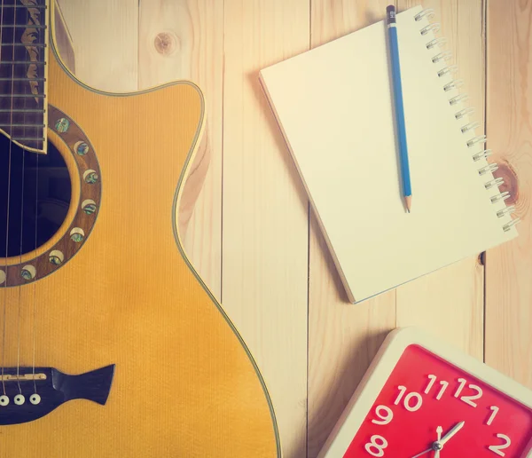 Guitarra con libro en blanco para el tiempo de escritura de música . — Foto de Stock