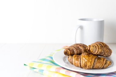 Çikolatalı kruvasan ve kahve kupa beyaz kopya alanı ile