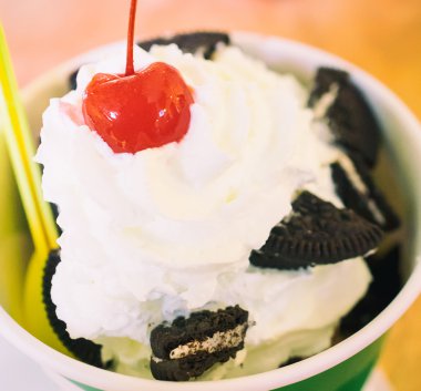 Bir dondurma kase üzerine kırmızı kiraz ile krem şanti