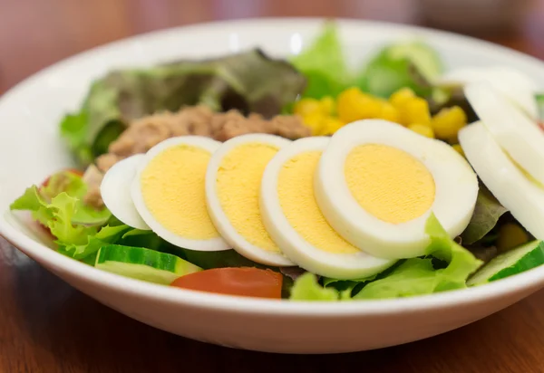 Японский салат из тунца с яйцами на белой тарелке — стоковое фото
