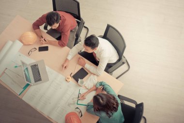 Üç müteahhit ekip ofiste başarılı bir toplantı yapıyor..