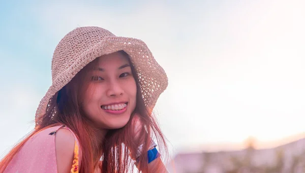 Happy Chinese Asian woman with summer hat portrait with sky background