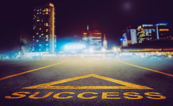 ビジネスの成功と経路の概念のためのナイトシティスカイラインにつながる道路上の成功矢印記号 — ストック写真
