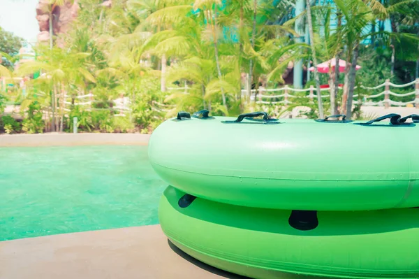 Large Green swim ring for water park slide on water park pool side.