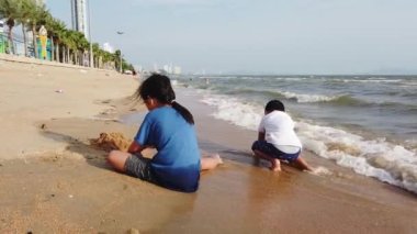 Pattaya Tayland 'ın sessiz plajında oynayan çocuklar..