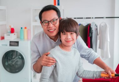 Mutlu Baba çocuğuna evi temizlemeyi öğretiyor. Aile işi ev işi konsepti için birlikte kanepe..