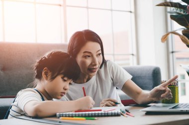 Asian Moter, New normal online eğitim kavramının karantina döneminde internet üzerinden online eğitim konusunda kızına yardım ediyor..