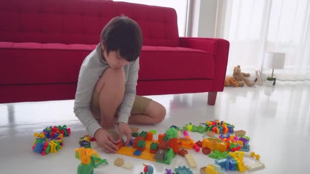 Mały Azjatycki Chłopiec Buduje Kolorowy Ceglany Blok Zabawki Podłodze Salonem — Wideo stockowe