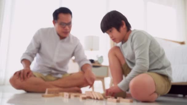 父と息子はおもちゃのブロックタワーで遊んでいます — ストック動画
