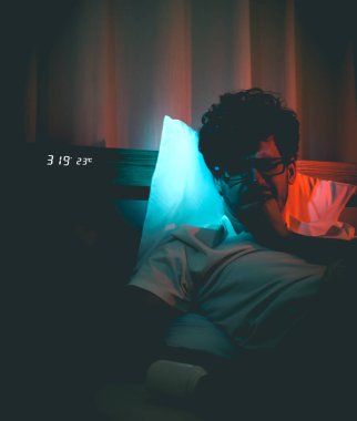 Depresyondaki uykusuzluk çeken beyaz adam gece geç saatlerde stres ve intihar konsepti için siyah haplarla başını yatakta tutuyor..