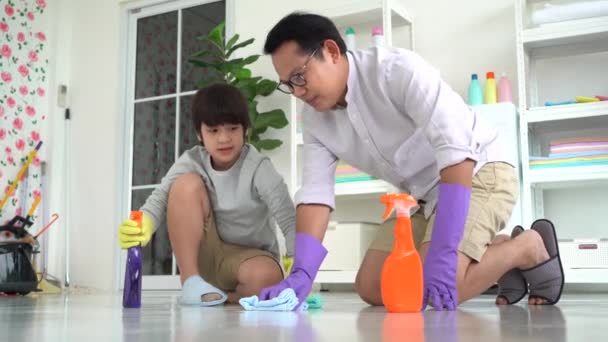 Pai Filho Está Limpando Chão Com Agente Limpeza Pulverização Garrafa — Vídeo de Stock