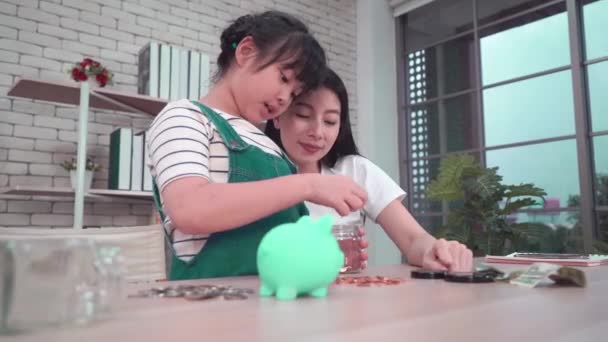 Asyalı Anne Çocuğunun Tasarruf Yatırım Hakkında Bilgi Edinmesi Için Domuzcuk — Stok video