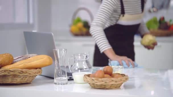 Frau Putzt Küchentisch Für Vorbereitung Auf Online Backkurs — Stockvideo