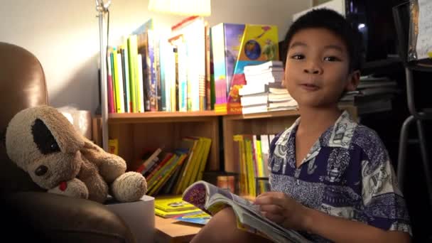 Aziatische Jongen Het Lezen Van Een Vrij Staarten Boek Naar — Stockvideo