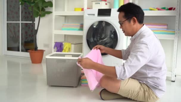 Asiatischer Vater Wäscht Kleidung Und Hält Handtuch Für Mann Hausarbeit — Stockvideo