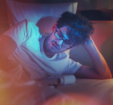 Yorgun beyaz erkek uykusuzluk tedavisi için uyku hapı almakta zorlanıyor..