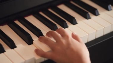 Yavaş çekimde piyano çalan bir elin kapalı görüntüsü..