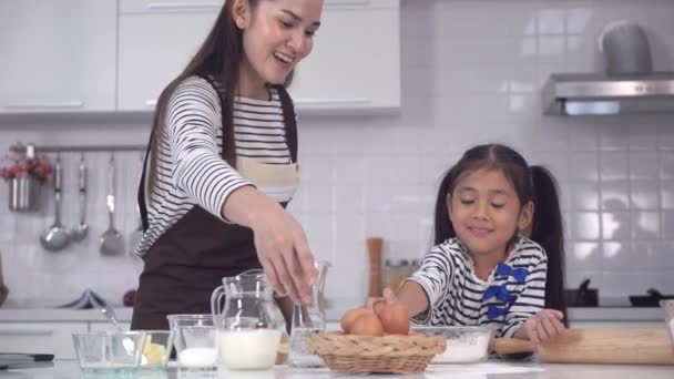 母と興奮した子供は家で一緒にパンや料理を学び一緒に働いています — ストック動画