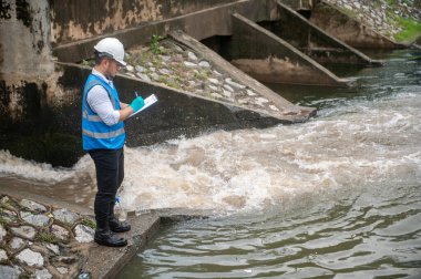 Bir su kaynağı memuru kirleticiler için bir kamu kuyusunu inceliyor.
