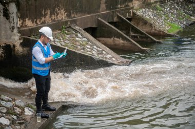 Su kaynağı memuru, ekosistemin korunması için kamu su kaynaklarında kirletici maddeleri kontrol ediyor.