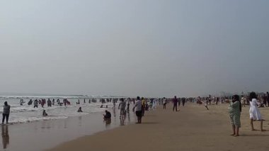 Puri-Odisha-India - 28 Aralık 2025 - İnsanlar kışın Puri, Blue Flag Beach 'te sahilde eğleniyorlar.
