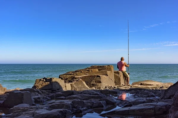 Rybář sedí na Guarita kámen — Stock fotografie