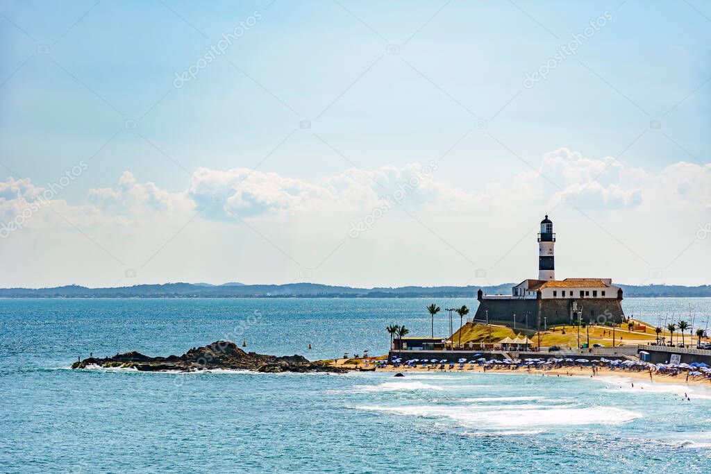 Barra beach and lighthouse seen from afar with the summer sun of Salvador in Bahia