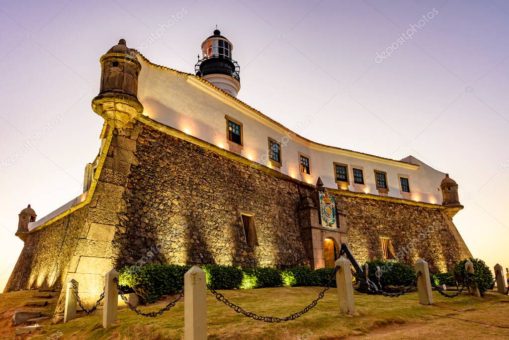 Facade of the old and historic fort and lighthouse in Barra during sunset in the city of Salvador, Bahia