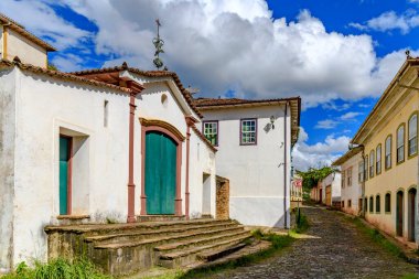 Ouro Preto 'da bir kaldırım taşı caddesinde tarihi bir kilise ve eski sömürge evleri.