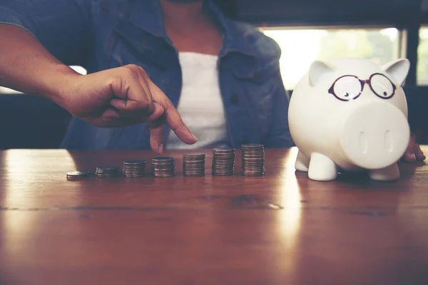 Women hand holding a stacking  coins in the public park, a saving money for future investment concept.Loan or saving money for real estate and property protection concept.