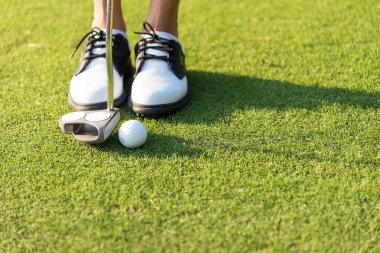 Golf sopası rotadan deliğe vuruyor. Top görüşlü golfçü.