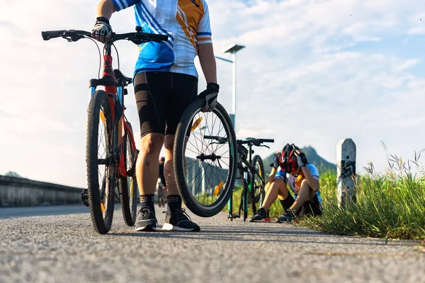女人骑自行车有一个问题 在路上需要轮胎漏气修理 在自行车伴侣的帮助下开车 — 图库照片