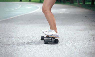 Asyalı kadınların bacakları kaykay ya da kaykay üzerinde. Spor aktivitesi yaşam tarzı konsepti, sağlıklı ve egzersiz