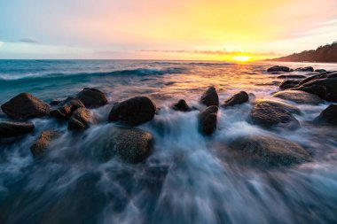 Deniz dalgası kayalara vurdu. Sahilde gün batımı, güzel doğal yaz deniz manzarası, Phuket, Tayland 