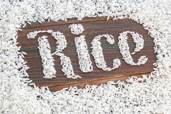 Слово рис пишеться літери рису на дерев'яній дошці — стокове фото