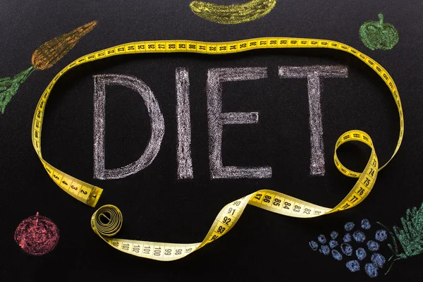 Diet word written in chalk with a yellow centimeter with vegetab