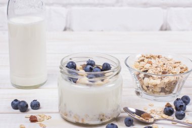 Yaban mersini ve tahıl cam bir kavanoza bir ahşap t ile yoğurt