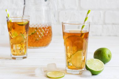 Bir dilim limon ile bir bardak buzlu çay. Beyaz ahşap tahta geri