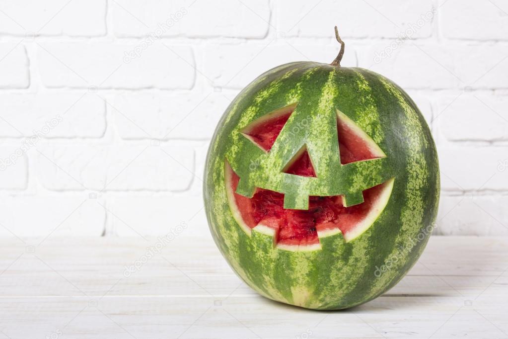 Smiling face of a water-melon on a Halloween like a pumpkin for 
