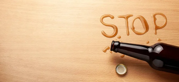 Bierflasche und verschüttetes Bier in Form des Wortes STOP. Alkoholverbot — Stockfoto